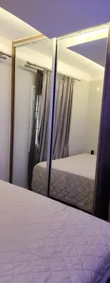 a reflection of a bedroom with a bed in a mirror at Oinos Luxury apartment in Faliraki