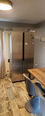 a kitchen with a stainless steel refrigerator and a wooden table at Oinos Luxury apartment in Faliraki