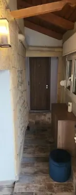 a room with a stone wall and a wooden door at Oinos Luxury apartment in Faliraki