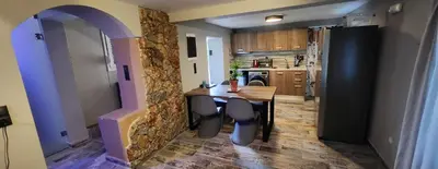 a kitchen with a table and a stone wall at Oinos Luxury apartment in Faliraki