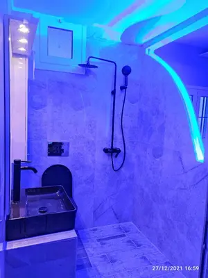 a bathroom with a tub and a shower with blue lights at Oinos Luxury apartment in Faliraki