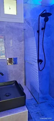 a bathroom with a shower with a black sink at Oinos Luxury apartment in Faliraki