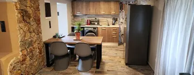 a kitchen with a wooden table and chairs and a kitchen with a kitchen at Oinos Luxury apartment in Faliraki