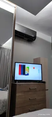 a flat screen tv on a dresser in a bedroom at Oinos Luxury apartment in Faliraki