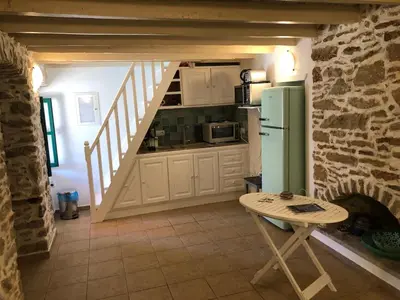 a kitchen with a refrigerator and a table in a room at La DESIRADE in Symi