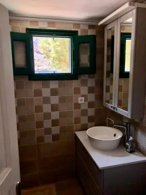 a bathroom with a sink and a window at La DESIRADE in Symi