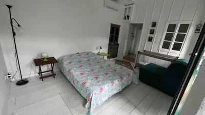 a bedroom with a bed and a table and a chair at La DESIRADE in Symi