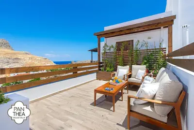 a patio with chairs and a table and the ocean at Villa Panthea in Líndos