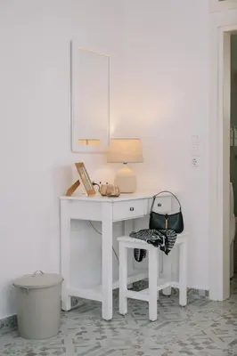 a white desk with a lamp and a chair at Aegean Nest in Koskinou