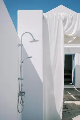 a shower in a room with a white curtain at Aegean Nest in Koskinou