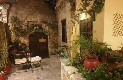 an outdoor patio with a table and chairs and plants at Saint Michel Apartments in Rhodes Town