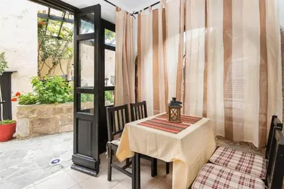 a table and chairs on a patio with a window at Saint Michel Apartments in Rhodes Town