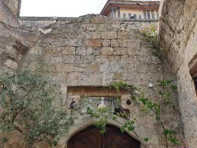 an old stone building with a door and flowers at Saint Michel Apartments in Rhodes Town