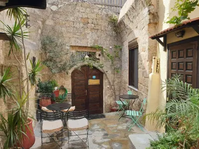 an outdoor patio with tables and chairs in a building at Saint Michel Apartments in Rhodes Town