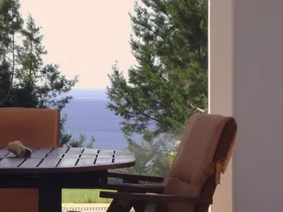 a bird sitting on a picnic table next to a window at Villa Chevalier in Kiotari
