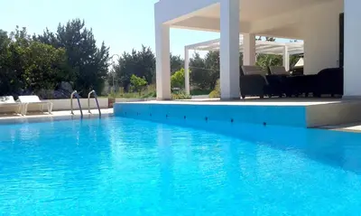 a swimming pool with blue water in a house at Villa Chevalier in Kiotari