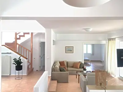 a living room with a couch and a staircase at Villa Chevalier in Kiotari