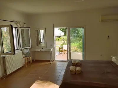 a living room with a table and sliding glass doors at Villa Chevalier in Kiotari
