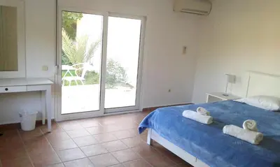 a bedroom with a blue bed with towels on it at Villa Chevalier in Kiotari