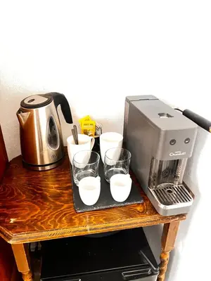 a coffee maker and glasses on a wooden table at Old Town Retreat in Rhodes Town