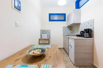 a kitchen with a wooden table with a bowl on it at Vassos Apartments in Líndos