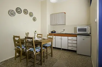a kitchen with a table and chairs and a microwave at Vassos Apartments in Líndos