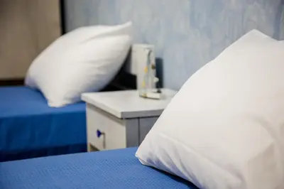 a bedroom with a bed with a pillow and a night stand at Vassos Apartments in Líndos