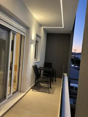 a balcony with a table and chairs and a window at Harriet Beauty Studios in Haraki