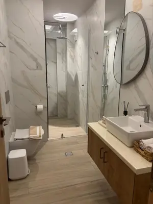 a bathroom with a shower and a sink and a mirror at Harriet Beauty Studios in Haraki