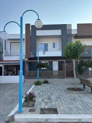 a building with two blue light poles in a courtyard at Harriet Beauty Studios in Haraki