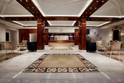 a lobby with a stage and chairs and a rug at Rodos Park in Rhodes Town