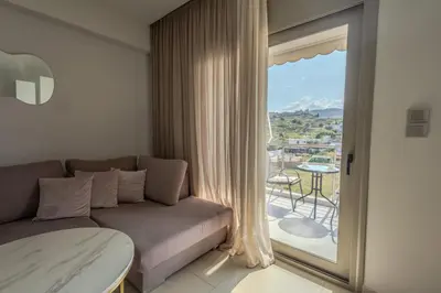 a living room with a couch and a large window at Castle View Archangelos in Archangelos