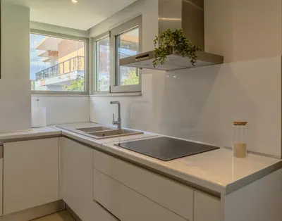 a white kitchen with a sink and a window at Castle View Archangelos in Archangelos