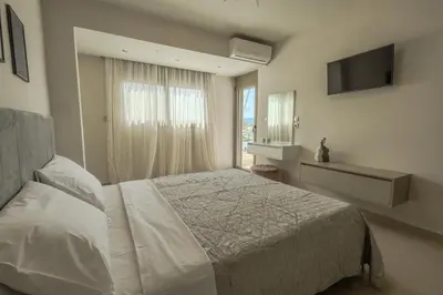 a bedroom with a white bed and a window at Castle View Archangelos in Archangelos