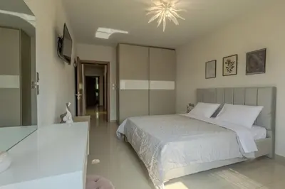 a bedroom with a bed and a chandelier at Castle View Archangelos in Archangelos