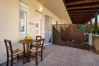 a patio with a table and chairs and a balcony at Levanta Cozy Apartments in Kalavarda Rhodes in Rhodes Town