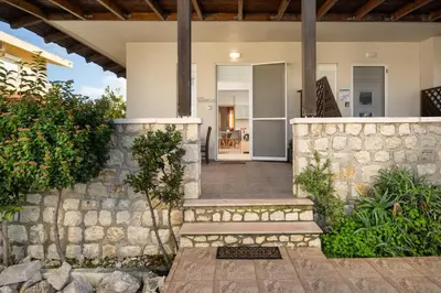 a house with a stone wall and a staircase at Levanta Cozy Apartments in Kalavarda Rhodes in Rhodes Town