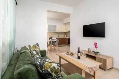 a living room with a green couch and a table at Levanta Cozy Apartments in Kalavarda Rhodes in Rhodes Town