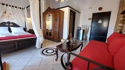 a living room with a bed and a red couch at Saint Michel Collection - Old Town in Rhodes Town