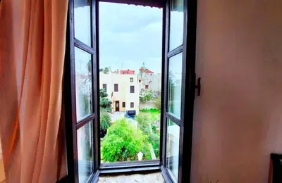 an open window with an orange curtain looking out at Saint Michel Collection - Old Town in Rhodes Town