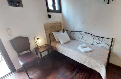 a small bedroom with a bed and a chair at Saint Michel Collection - Old Town in Rhodes Town