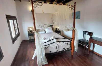 a bedroom with a canopy bed with a wooden floor at Saint Michel Collection - Old Town in Rhodes Town