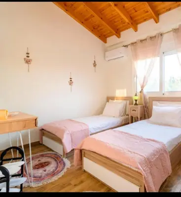 a bedroom with two beds and a desk and a window at Blue Waves House 2 in Soroni