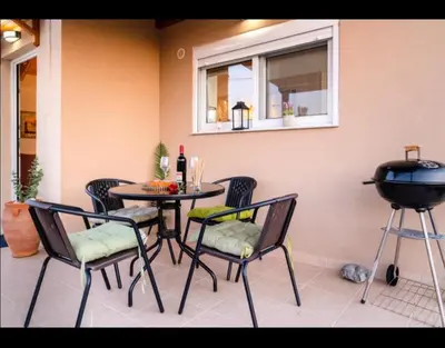 a patio with a table and chairs and a grill at Blue Waves House 2 in Soroni
