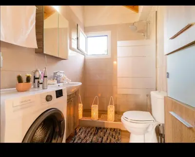 a bathroom with a washing machine and a toilet at Blue Waves House 2 in Soroni
