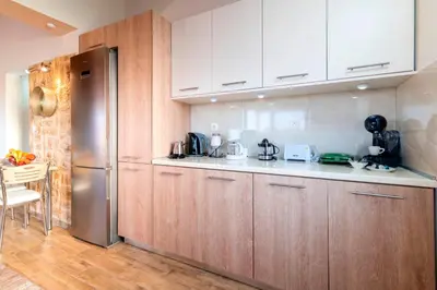 a kitchen with wooden cabinets and a stainless steel refrigerator at Blue Waves House 2 in Soroni