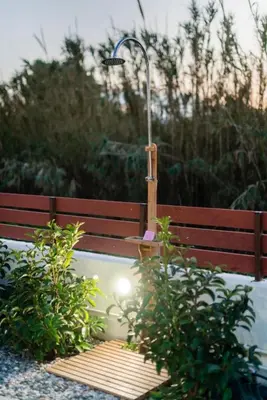 a bench with a light on it next to some plants at Blue Waves House 2 in Soroni