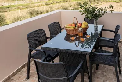 a table with a basket of fruit on a balcony at Serenity Luxury Villa in Paradisi Rhodes in Rhodes Town