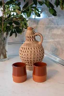 a vase sitting on a table next to two cups at Serenity Luxury Villa in Paradisi Rhodes in Rhodes Town
