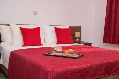 a tray of food on a bed with red pillows at Serenity Luxury Villa in Paradisi Rhodes in Rhodes Town